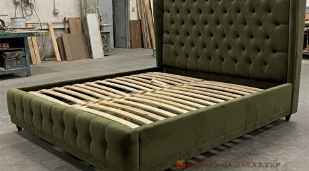 зеленая мягкая кровать с мягким изголовьем